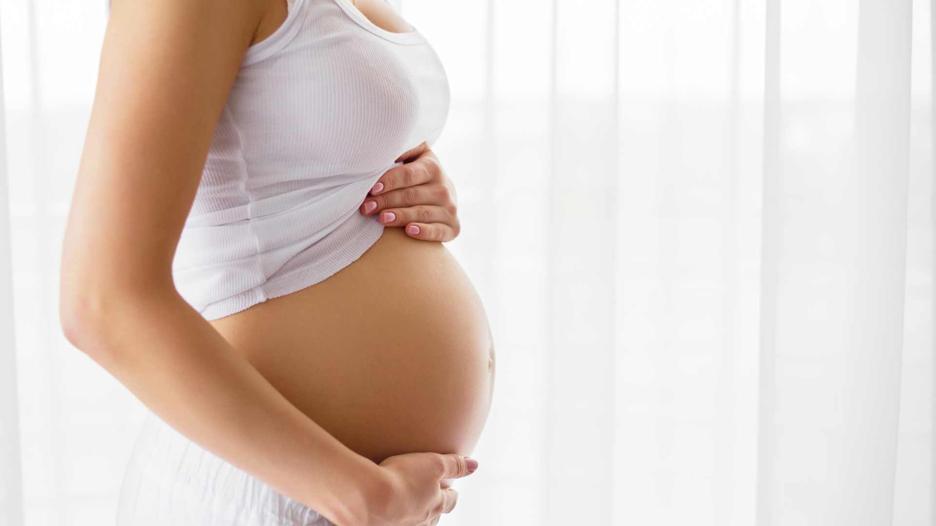 Schwangere Frau hält ihre Hände auf den Bauch, Endometriose Kinderwunsch